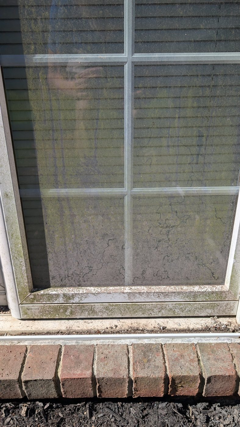 Dirty window with hard water spots before professional cleaning