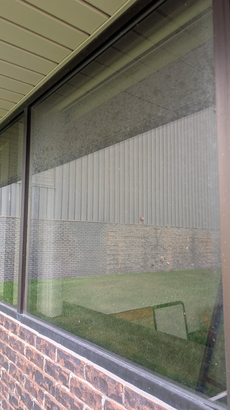 Hazy, dirty storefront glass before professional commercial window cleaning